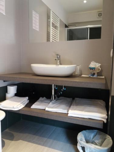 a bathroom with a sink and a counter with towels at Hotel Sole Holiday in Arco