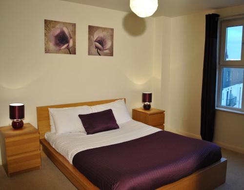 エディンバラにあるDreamhouse Apartments Edinburgh City Centreのベッドルーム1室(ベッド1台、ランプ2つ、窓付)