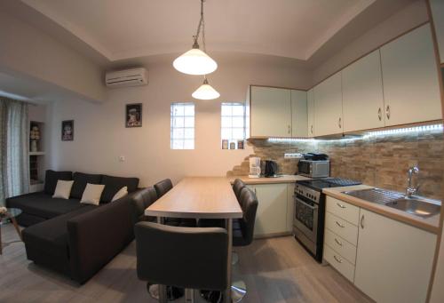 a kitchen and living room with a table and a couch at Sousouro House in Kassiopi