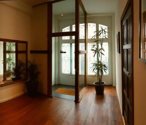 a hallway with two potted plants and a mirror at De Mot B&B in Brussels