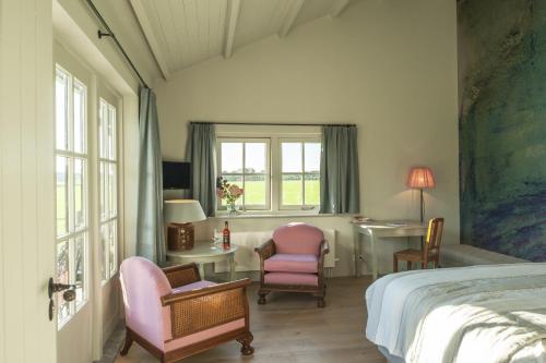 sypialnia z łóżkiem, 2 krzesłami i biurkiem w obiekcie Dromen in Drempt w mieście Drempt