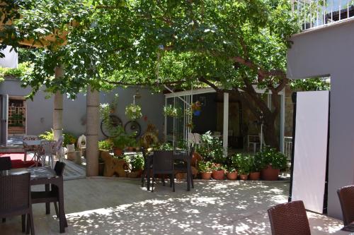 een patio met tafels en stoelen onder een boom bij Held Hotel in Antalya