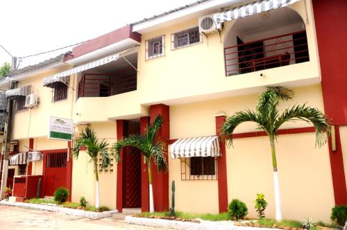 un edificio con palmeras delante en Résidences Touristhotel en Abiyán