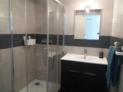 y baño con ducha, lavabo y espejo. en Apartamento Alvor, en Alvor