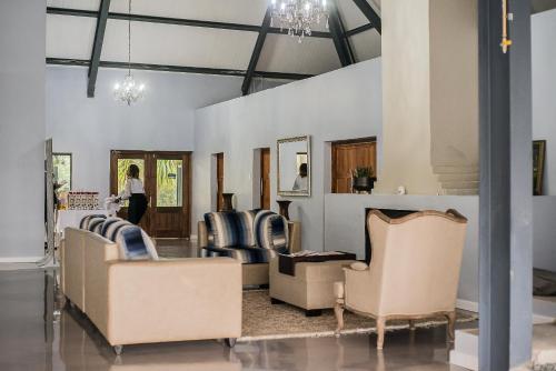 a waiting room with chairs and a woman in the background at Mount Shekinah Country Hotel in Balgowan