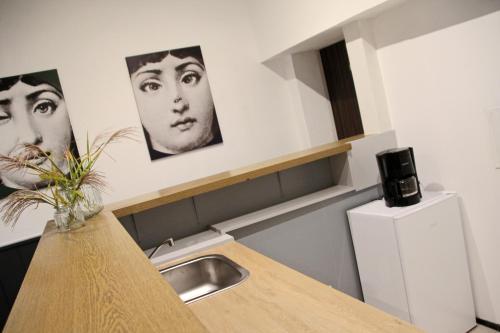 a kitchen with a sink and two pictures on the wall at Pension Kupferkanne in Dingolfing