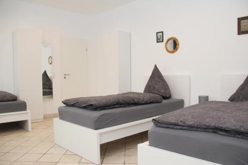 two beds in a room with white walls at Pension Kupferkanne in Dingolfing