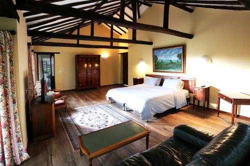 - un salon avec un lit et un canapé dans l'établissement Hotel Plazuela de San Agustín, à Villa de Leyva