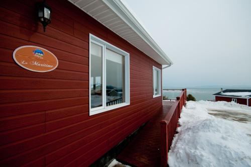 a red building with a window on the side of it at Domaine Frais Air in La Malbaie