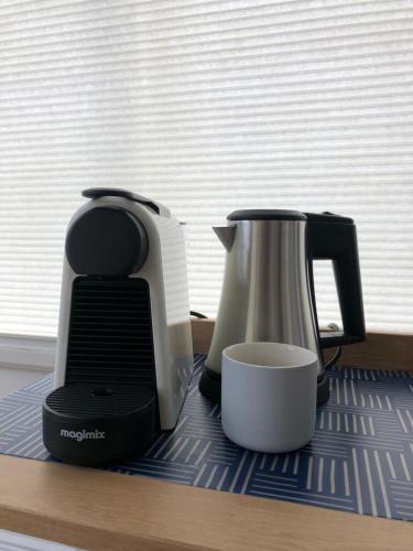 una taza y una cafetera sentadas en un mostrador en PH93 Amsterdam Central, en Ámsterdam