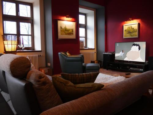 a living room with a couch and a tv at Schloss Gmünd in Gmünd