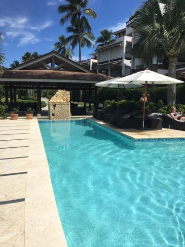 ein Pool mit Sonnenschirm und ein Gebäude in der Unterkunft Your Second Home Away in Las Terrenas