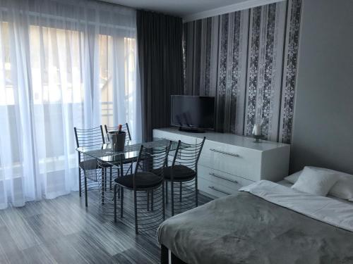 1 dormitorio con 1 cama, mesa y sillas en Apartament Villa Marea en Międzyzdroje