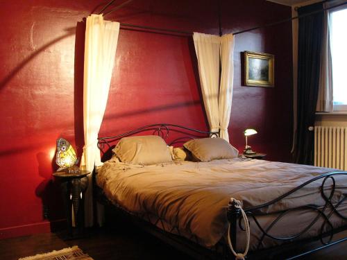 a bedroom with a large bed with a red wall at B&B Lady Jane in Bruges