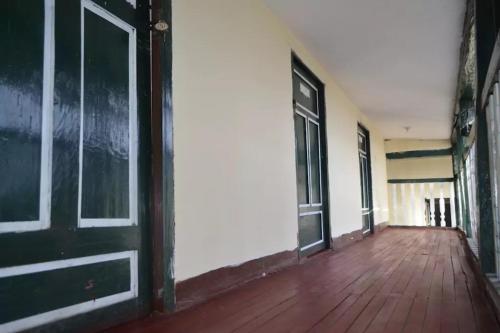 an empty room with a door and a wooden floor at Casa Vieja Posada in Pesca