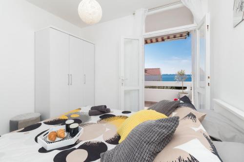 a bedroom with a bed with a view of the ocean at Apartman Roko in Petrcane