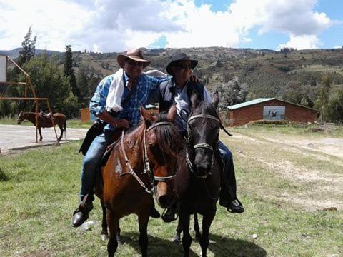 two people riding on the backs of horses at Casa Vieja Posada in Pesca