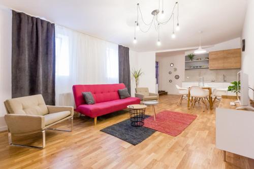 een woonkamer met een rode bank en stoelen bij Quiet Old Town Hideout in Cluj-Napoca