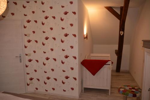 a room with a white wall with red flowers on it at Ferienappartements "Landromantik" in Bautzen