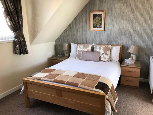 a bedroom with a bed and two night stands at The Miclaran in Shanklin