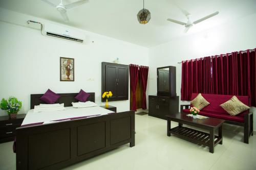 una camera con un grande letto e una tenda rossa di Green Garden Resort a Kuttālam