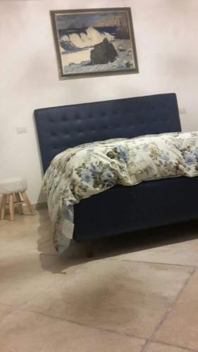 a bed with a blue headboard with a blanket on it at Villa Masullo in Mercogliano