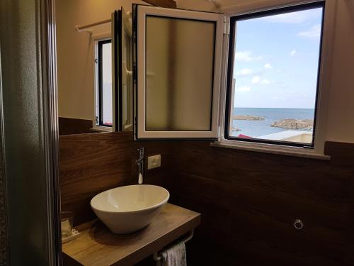 La salle de bains est pourvue d'un lavabo et de 2 fenêtres. dans l'établissement La Rosa dei Venti, à Isola delle Femmine