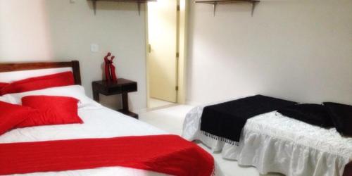 1 dormitorio con 2 camas con sábanas rojas y blancas en Milleniu's Pousada e Restaurante, en Piranhas