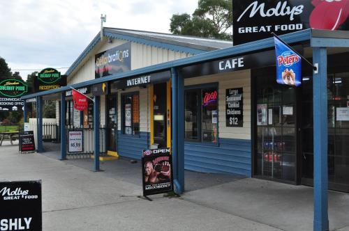 a row of stores with signs in front of them at Strahan Retreat Holiday Park in Strahan