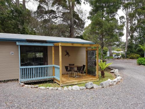 a small house with a table and chairs in it at Strahan Retreat Holiday Park in Strahan