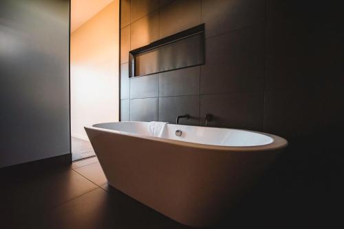 a white bath tub in a bathroom with a mirror at The View Lake Tekapo in Lake Tekapo