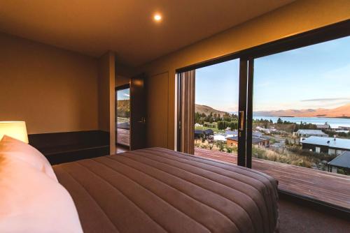 a bedroom with a large bed and a large window at The View Lake Tekapo in Lake Tekapo