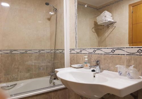 a bathroom with a sink and a shower and a bath tub at Hotel Reina Isabel in Medina del Campo