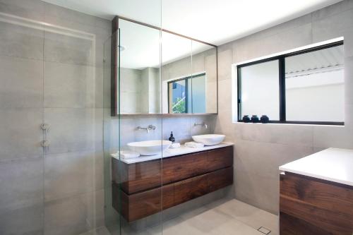 a bathroom with two sinks and a mirror at Aarons Luxury Retreat in Noosaville