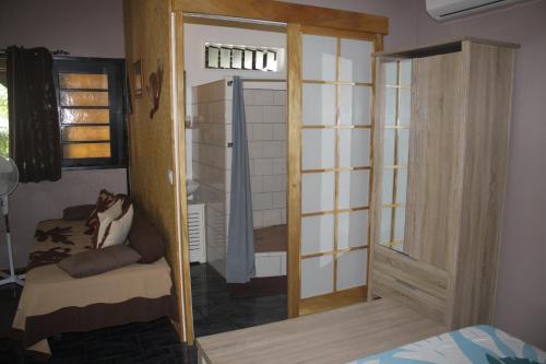 a room with a sliding glass door and a bed at Fare D'hôtes Tutehau in Papeete