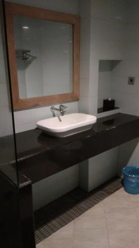 un baño con lavabo y espejo en Antika Hotel, en Rembang