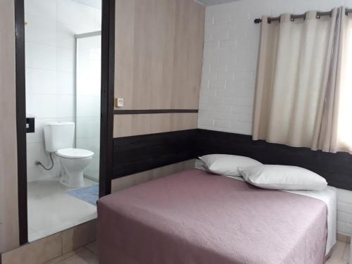 una camera da letto con un letto e un bagno con wc di Hotel Rizzi a Encantado