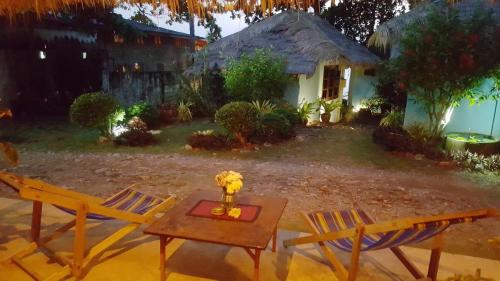 象島的住宿－藍天度假酒店，一张桌子和两把椅子以及一张桌子和一所房子