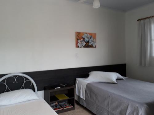 una camera da letto con due letti e una finestra di Hotel Rizzi a Encantado