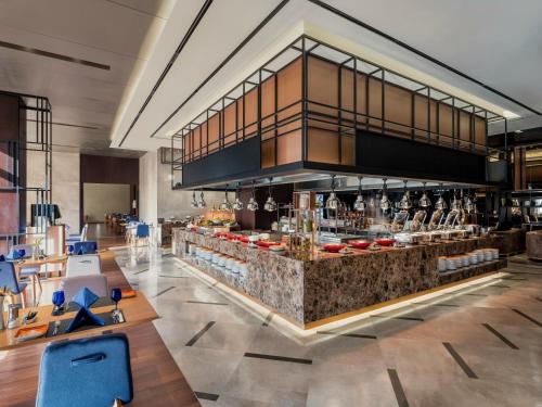 a bar in a restaurant with tables and chairs at Novotel Suites Ambassador Seoul Yongsan in Seoul