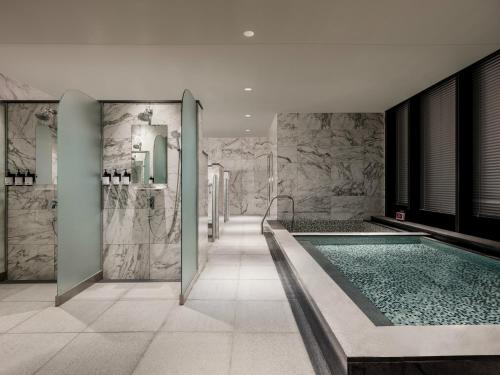 baño con piscina y paredes de mármol en Novotel Suites Ambassador Seoul Yongsan en Seúl