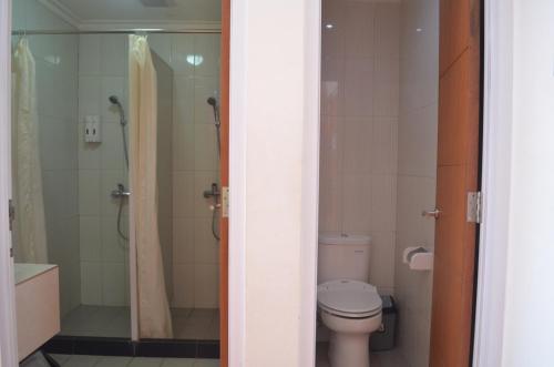 a bathroom with a toilet and a shower at EDU Hostel in Yogyakarta
