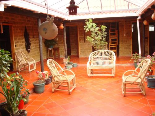 a patio with chairs and potted plants on it at Monzaque- paraíso de bachué in El Barrial