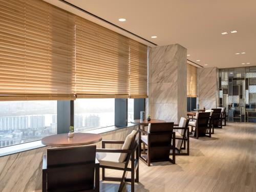 a restaurant with tables and chairs and large windows at Novotel Ambassador Seoul Yongsan in Seoul