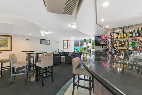 a bar in a restaurant with tables and chairs at The Wellington Apartment Hotel in Brisbane