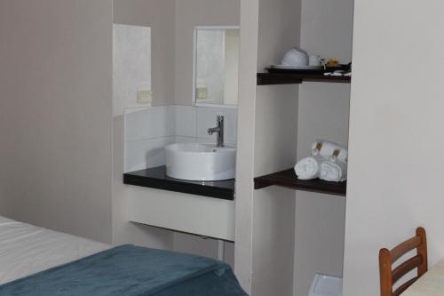 baño con lavabo y cama en Bohemia Resort Cairns, en Cairns