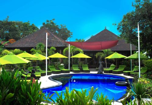 a swimming pool with chairs and umbrellas at Damara Lembongan in Nusa Lembongan