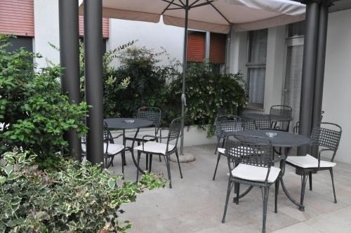 um pátio com mesas e cadeiras debaixo de um guarda-sol em Al Fogher em Treviso
