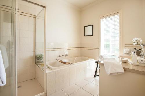 a white bathroom with a tub and a shower at Emerald Lodge in Emerald