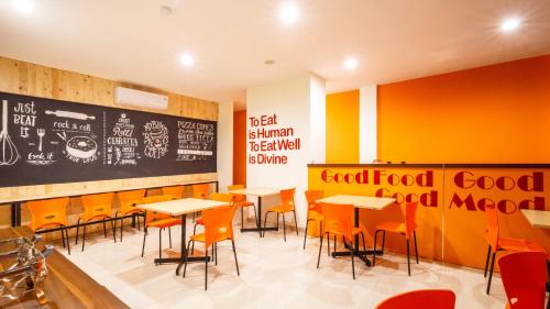 a classroom with tables and chairs and a chalkboard at Front One Inn Muntilan in Muntilan